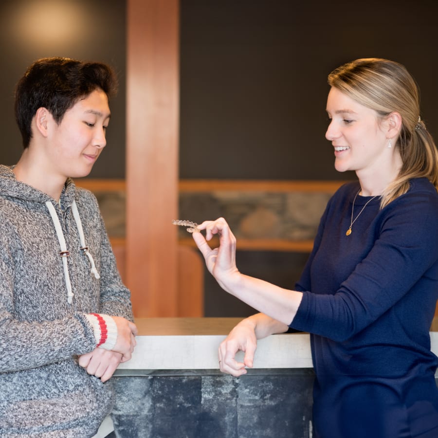 Dr. Kosmowski shows a patient an Invisalign aligner tray.
